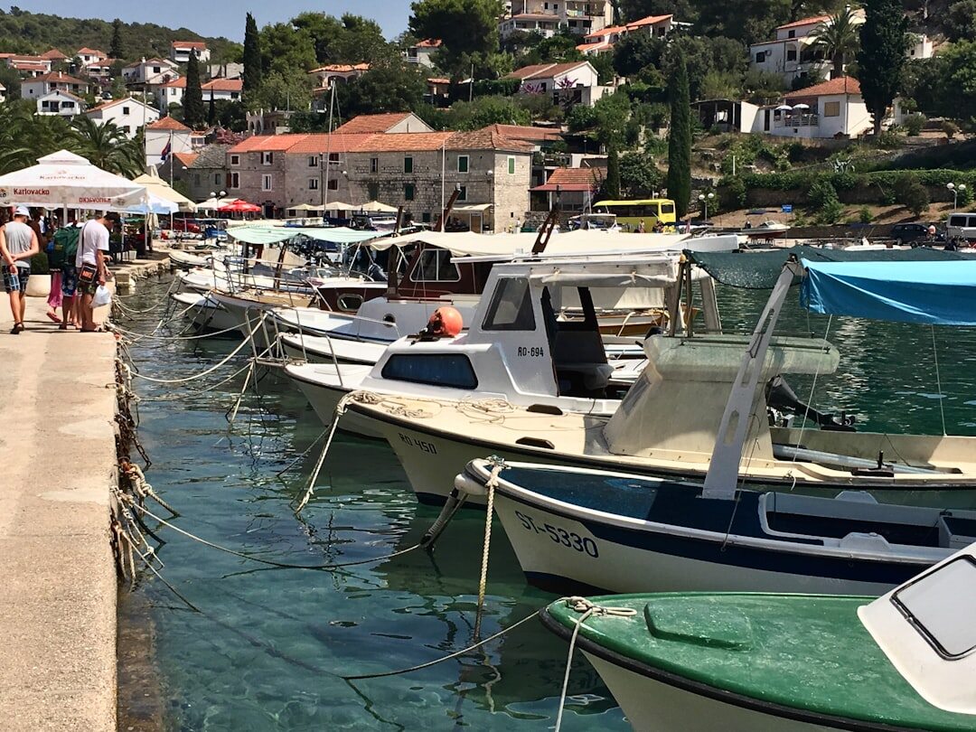Elderly Croatian fisherman mending nets on a stone quay