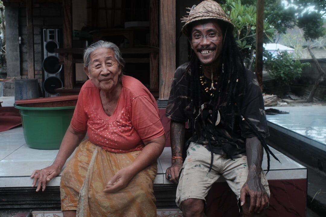 Photographer interviewing an elderly man on a village porch